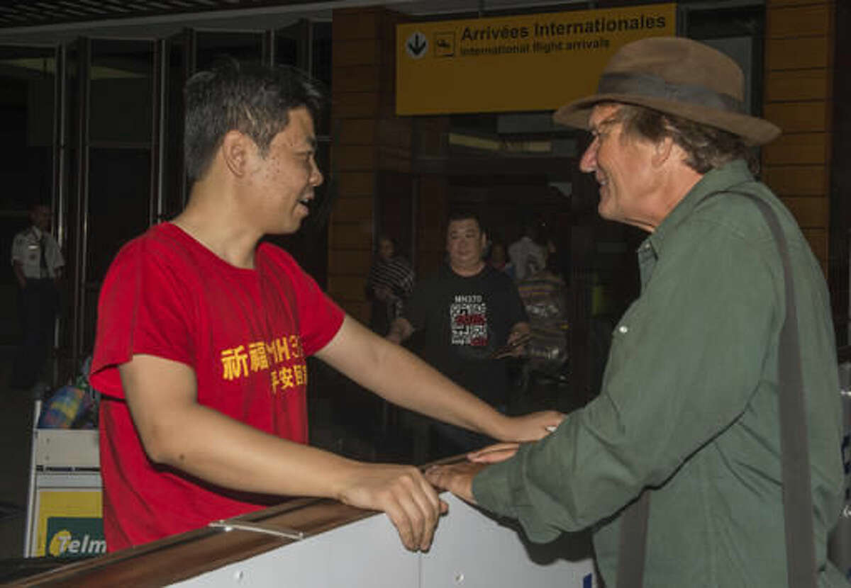 Jiang Hui Be of China, left, a relatives of passenger of a missing Malaysia plane, is received by American wreckage hunter Blaine Gibson, during their arrival at the Ivato International Airport in Antananarivo, Madagascar, Saturday, Dec. 3, 2016. Relatives of some of the 239 people who were on a Malaysia Airlines plane that vanished in 2014 have arrived in Madagascar to ask for help in the search for debris from the missing aircraft that may have drifted across the Indian Ocean. (AP Photo/Alexander Joe)