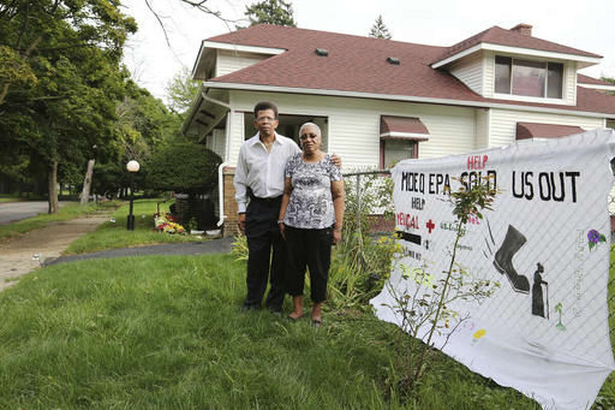 In this Sept. 8, 2016 photo, Rufus McWilliams, 61, left, and Mosetta Jackson, 81, stand on Concord Street together in front of Jackson's home of over 60 years in Detroit. The two are the president and vice-president of Eastside Coalition For Environmental Justice, who have been in this East Town neighborhood for over 60 years. They are adamantly opposed to the existence of the Ecology hazardous waste facility that is a few blocks from their home. The DEQ is considering allowing it to expand in size. (Regina H. Boone/Detroit Free Press via AP)