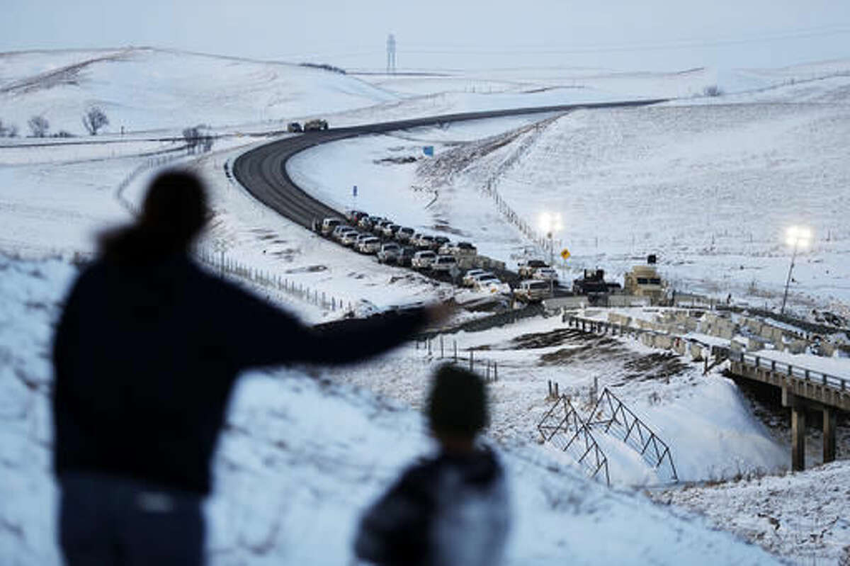 Law enforcement vehicles line a road leading to a blocked bridge next to the Oceti Sakowin camp where people have gathered to protest the Dakota Access oil pipeline in Cannon Ball, N.D., Saturday, Dec. 3, 2016. (AP Photo/David Goldman)
