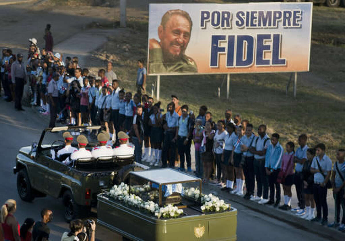 The motorcade carrying the ashes of the late Cuban leader Fidel Castro makes i's final journey towards the Santa Ifigenia cemetery in Santiago, Cuba Sunday, Dec. 4, 2016. Thousands of people lined the short route from the Plaza Antonio Maceo or Plaza of the Revolution to the cemetery where the ashes will be buried in a private ceremony near the grave of Cuba's independence hero Jose Marti. (AP Photo/Ramon Espinosa)