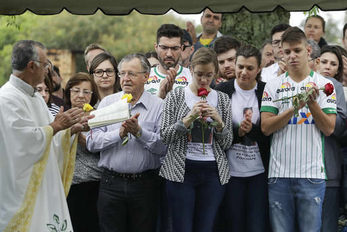 Relatives attend the burial of Chapecoense soccer team's late president Sandro Pallaoro, who died in a plane crash in Colombia, in Chapeco, Brazil, Sunday, Dec. 4, 2016. The accident Monday in the Colombian Andes claimed most of the team's players and staff as it headed to the finals of one of Latin America's most important club tournaments. (AP Photo/Andre Penner)