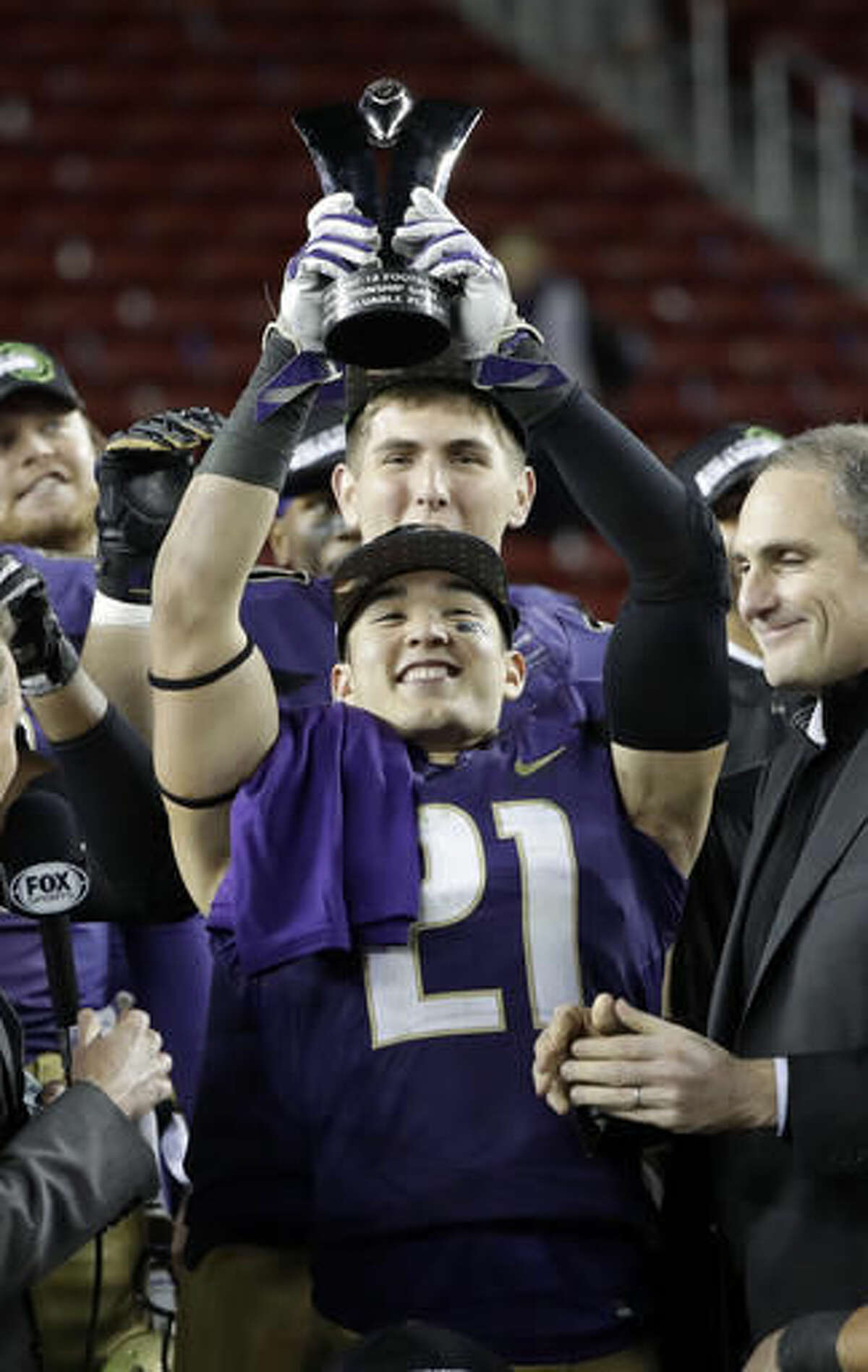 Washington defensive back Taylor Rapp (21) holds the game MVP trophy after Washington's 41-10 win over Colorado in the Pac-12 Conference championship NCAA college football game Friday, Dec. 2, 2016, in Santa Clara, Calif. (AP Photo/Marcio Jose Sanchez)