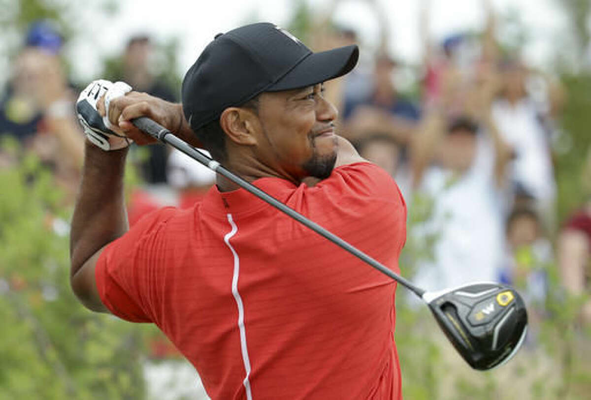 Tiger Woods watches his tee shot on the first hole during the final round at the Hero World Challenge golf tournament, Sunday, Dec. 4, 2016, in Nassau, Bahamas. (AP Photo/Lynne Sladky)