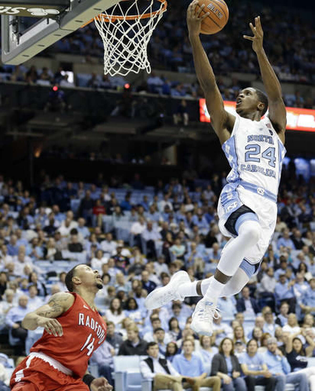 North Carolina's Kenny Williams (24) drives to the basket as Radford's Justin Cousin (14) defends during the first half of an NCAA college basketball game in Chapel Hill, N.C., Sunday, Dec. 4, 2016. (AP Photo/Gerry Broome)