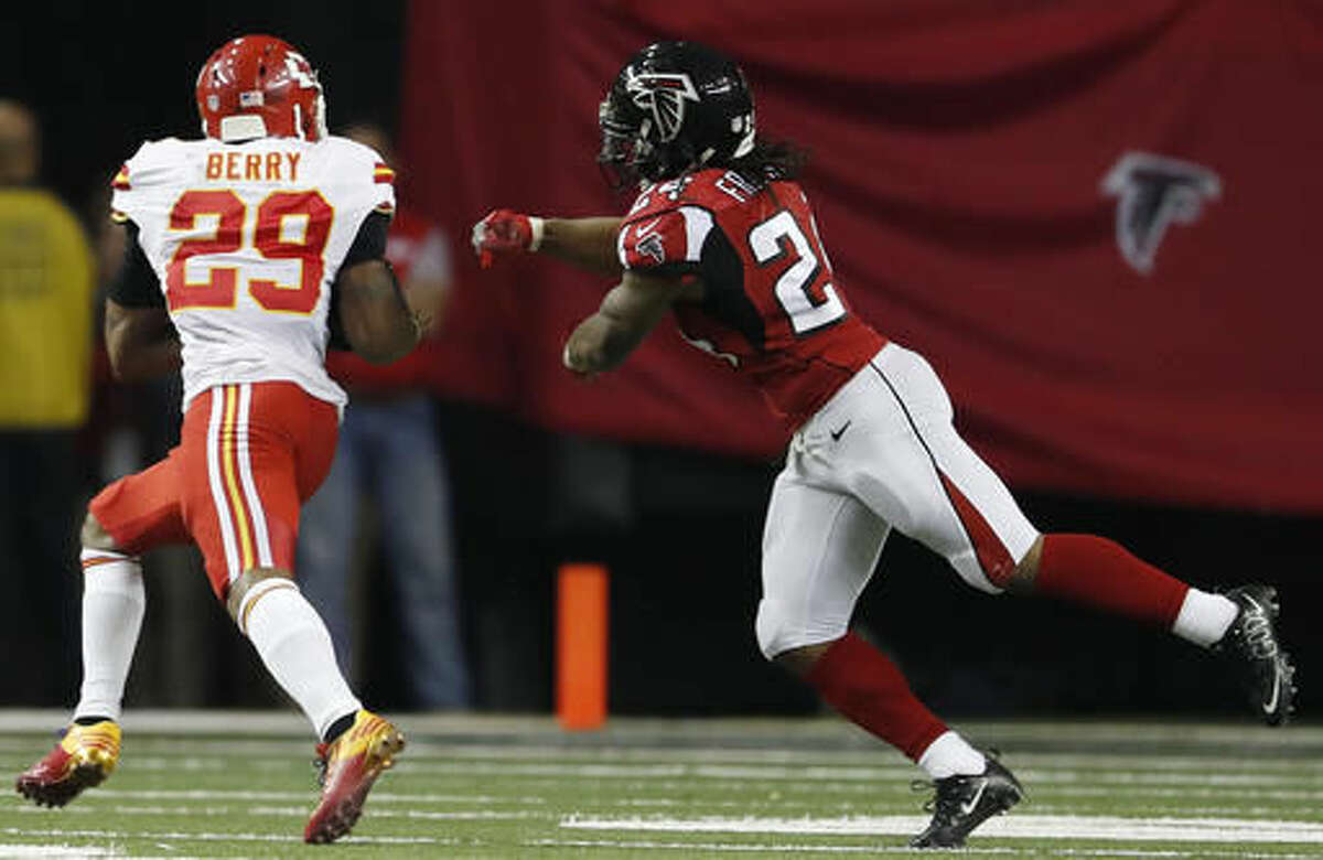 Kansas City Chiefs strong safety Eric Berry (29) runs an intercepted ball against Atlanta Falcons running back Devonta Freeman (24) during the first half of an NFL football game, Sunday, Dec. 4, 2016, in Atlanta. Berry scored on the play. (AP Photo/John Bazemore)