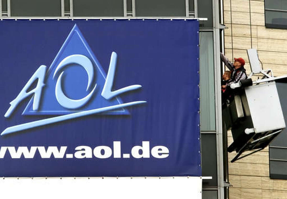 FILE - In this March 17, 2000, file photo, window cleaners work at the front of the headquarters of AOL Europe in Hamburg, Germany. A California woman stumbled upon a voice from the past during a trip to Ohio over the weekend when she discovered her Uber driver was the man behind America Online’s famous “You’ve Got Mail” greeting. Brandee Barker was in the Cleveland area to campaign for Hillary Clinton when she got into an Uber driven by Elwood Edwards. After Edwards told her about his claim to fame, she took a video of him saying the phrase and posted it on Twitter on Nov. 5, 2016. (AP Photo/Michael Probst, File)