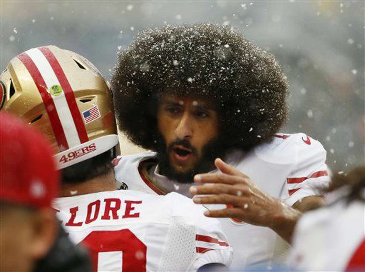 San Francisco 49ers quarterback Colin Kaepernick, right, hugs San Francisco 49ers linebacker Nick Bellore (50) before an NFL football game against the Chicago Bears, Sunday, Dec. 4, 2016, in Chicago. (AP Photo/Nam Y. Huh)