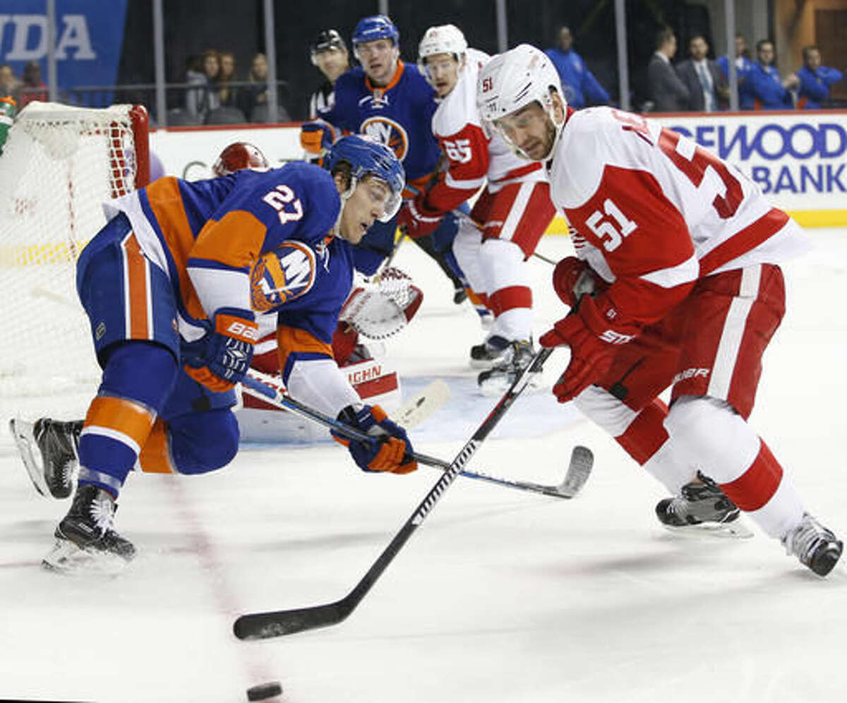 New York Islanders' left wing Anders Lee (27) loses his balance as Detroit Red Wings' center Frans Nielsen (51), of Denmark, takes control of the puck during the second period of an NHL hockey game, Sunday, Dec. 4, 2016, in New York. (AP Photo/Kathy Willens)