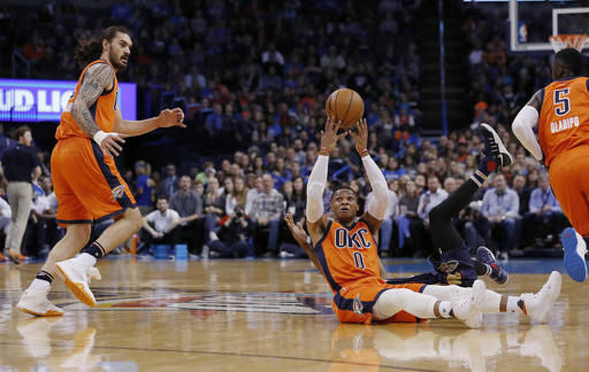 Oklahoma City Thunder guard Russell Westbrook (0) passes the ball behind and over head to Oklahoma City Thunder center Steven Adams (12) during a play against the New Orleans Pelicans in the first half of an NBA basketball game in Oklahoma City, Sunday, Dec. 4, 2016. (AP Photo/Alonzo Adams)