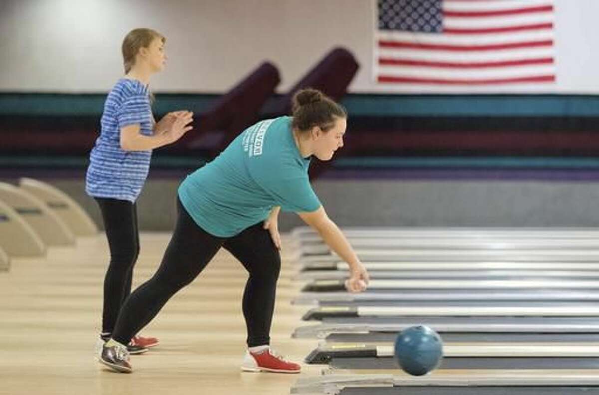 ADVANCE FOR USE SATURDAY, NOV. 19 - In this Tuesday, Nov. 1, 2016 photo, Omaha North senior Ciera Pieters, right, rolls while Hannah Faber watches her ball in Omaha, Neb. It's the first season for North High and more than 40 other high school unified bowling teams across the state.(Matt Miller/Omaha World-Herald via AP)