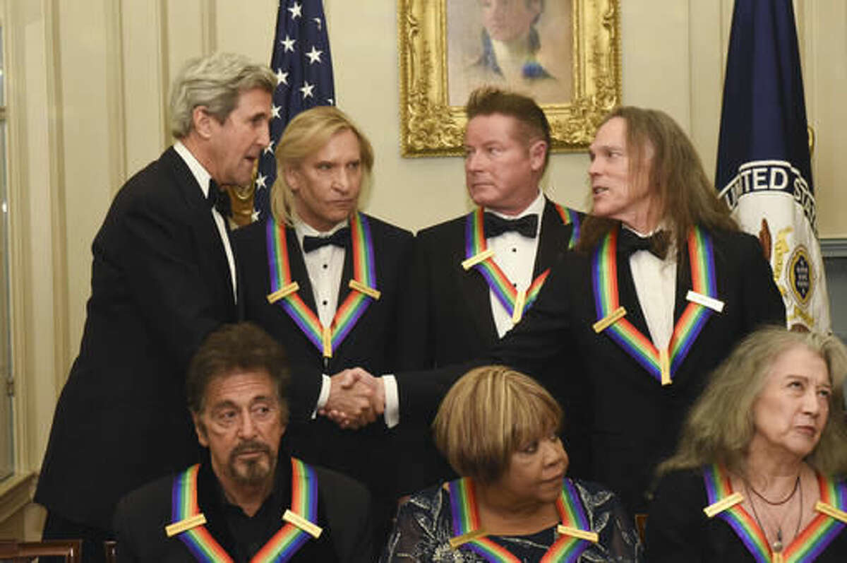 Secretary of State John Kerry, top left, meets with Eagles members Tim Schmit, right, Don Henley, second right, and Joe Walsh, second left, all 2016 Kennedy Center Honorees following the State Department for the Kennedy Center Honors gala dinner, Saturday, Dec. 3, 2016, in Washington. Also photographed are honorees, front row from left, Al Pacino, Mavis Staples and Martha Argerich. (AP Photo/Kevin Wolf)