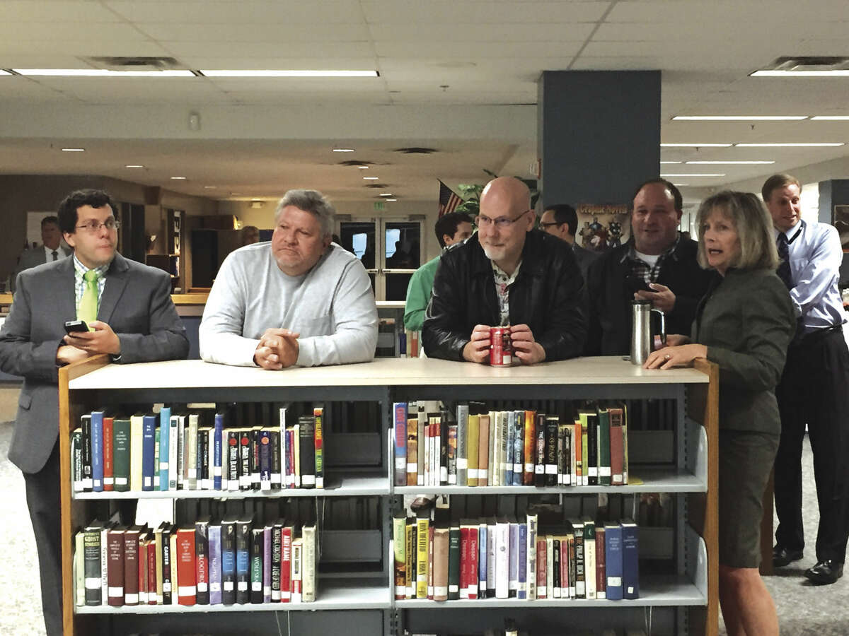 Edwardsville District 7 Superintendent Dr. Lynda Andre, right, watches along with other interested individuals in the Edwardsville High School Media Center as election results come in Tuesday night.