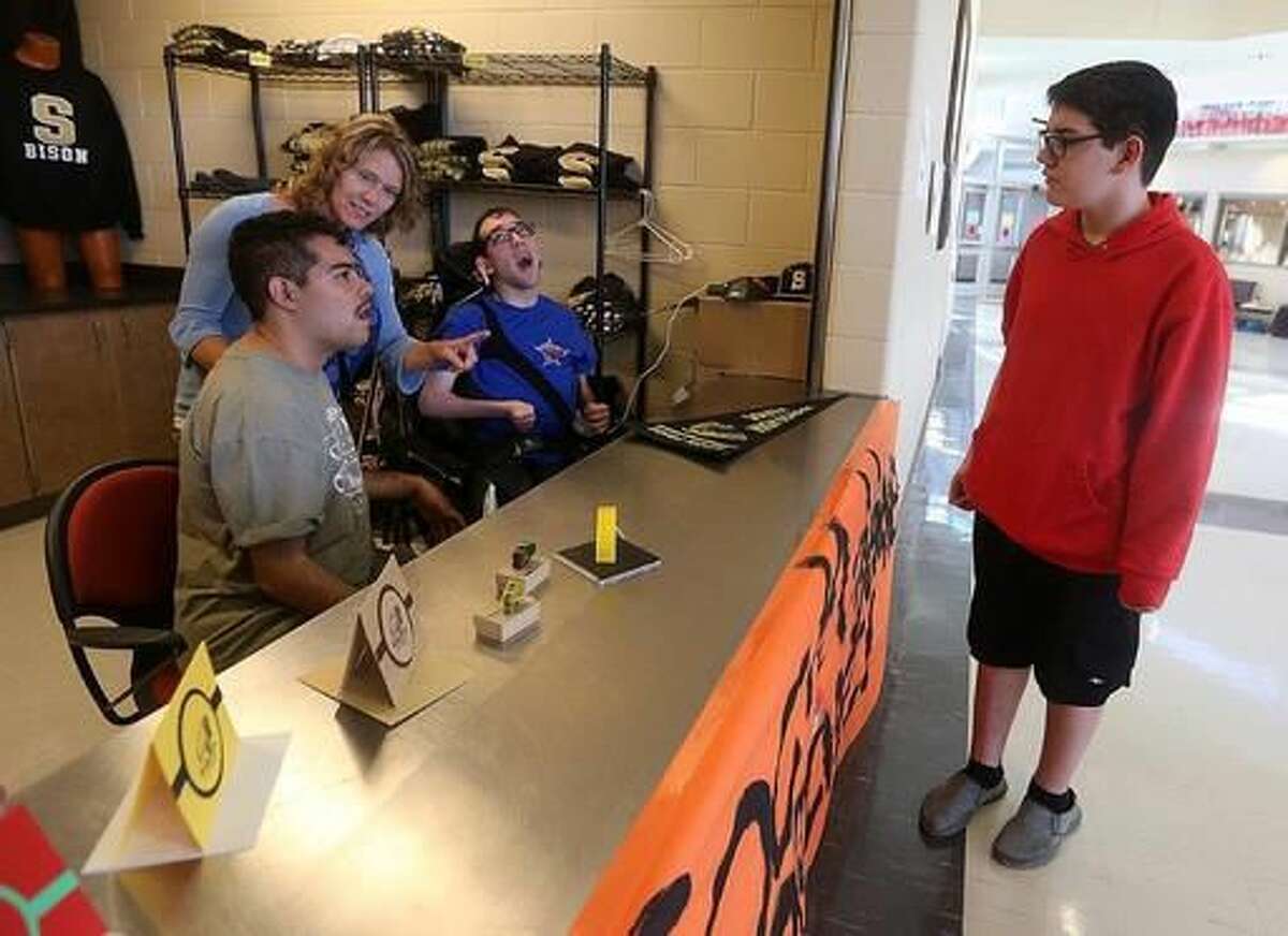 Katie Rhodes helps Derjam Salinas and Austin Pope converse with freshman Jacob Saner about some of the products they made representing Cheyenne's South High on Tuesday at teh school. Riccardo Castle and Katie Rhoads recently received a $996 grant from the Cheyenne Schools Foundation to help students with severe disabilities learn job skills at the school and in the community. (Blaine McCartney/The Wyoming Tribune Eagle via AP)