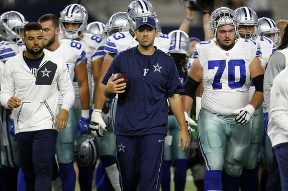 FILE - In this Oct. 30, 2016, file photo, Dallas Cowboys' Tony Romo, center, and teammates walk off the field after warm ups before an NFL football game against the Philadelphia Eagles in Arlington, Texas. Romo is running the scout team in practice even though Dallas' starting quarterback the past 10 years looks ready to return from a back injury. (AP Photo/Roger Steinman, File)