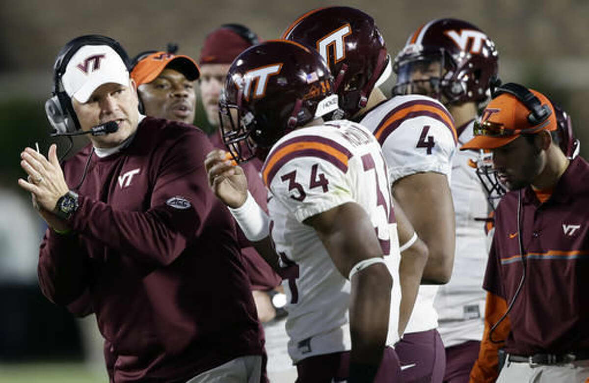 Virginia head coach Justin Fuente, left, applauds his players Travon McMillian (34) and Jerod Evans (4) during the second half of an NCAA college football game in Durham, N.C., Saturday, Nov. 5, 2016. Virginia Tech won 24-21. (AP Photo/Gerry Broome)