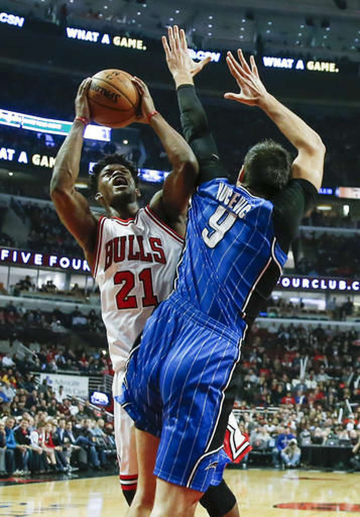 Orlando Magic center Nikola Vucevic, right, fouls Chicago Bulls guard Jimmy Butler, left, during the first half of an NBA basketball game, Monday, Nov. 7, 2016, in Chicago. (AP Photo/Kamil Krzaczynski)