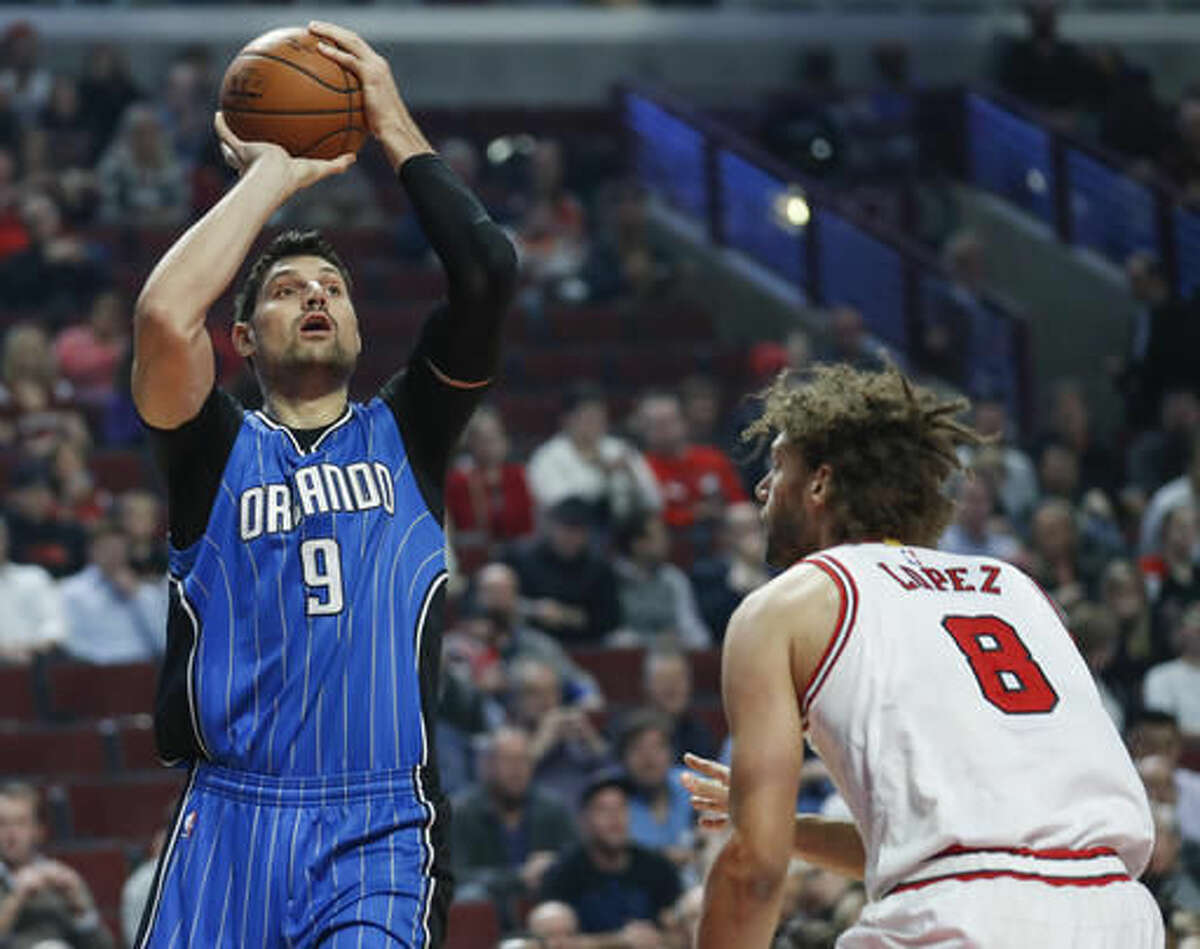 Orlando Magic center Nikola Vucevic, left, shoots against Chicago Bulls center Robin Lopez, right, during the first half of an NBA basketball game, Monday, Nov. 7, 2016, in Chicago. (AP Photo/Kamil Krzaczynski)