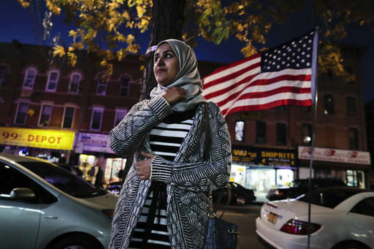 Enas Almadhwahi, an immigration outreach organizer for the Arab American Association of New York, stands for a photo along Fifth Avenue in the Bay Ridge neighborhood of Brooklyn, Friday, Nov. 11, 2016, in New York. American Muslims are reeling over Donald Trump's victory, wondering what the next four years will bring after a campaign in which he proposed creating a national database of Muslims, monitoring all mosques and banning some or all Muslims from entering the country. (AP Photo/Julie Jacobson)