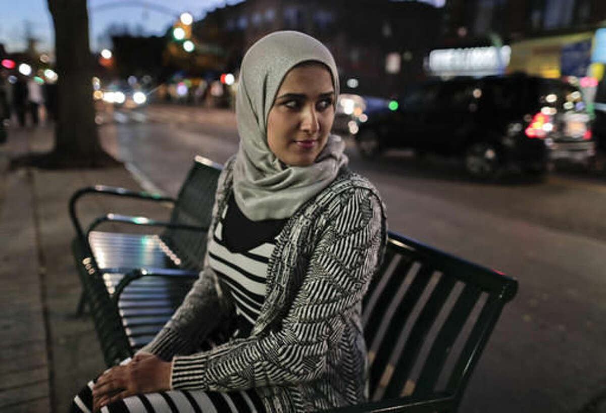 Enas Almadhwahi, an immigration outreach organizer for the Arab American Association of New York, sits for a photo along Fifth Avenue in the Bay Ridge neighborhood of Brooklyn, Friday, Nov. 11, 2016, in New York. The 28-year-old Yemeni immigrant who has been in the U.S. since 2008, became a citizen in 2016 and voted for the first time. To mark the occasion, she brought her 7-year-old daughter, along with some co-workers. "At that moment, I was so happy," she said. The next day, when she told her daughter Trump had won, the girl cried. (AP Photo/Julie Jacobson)