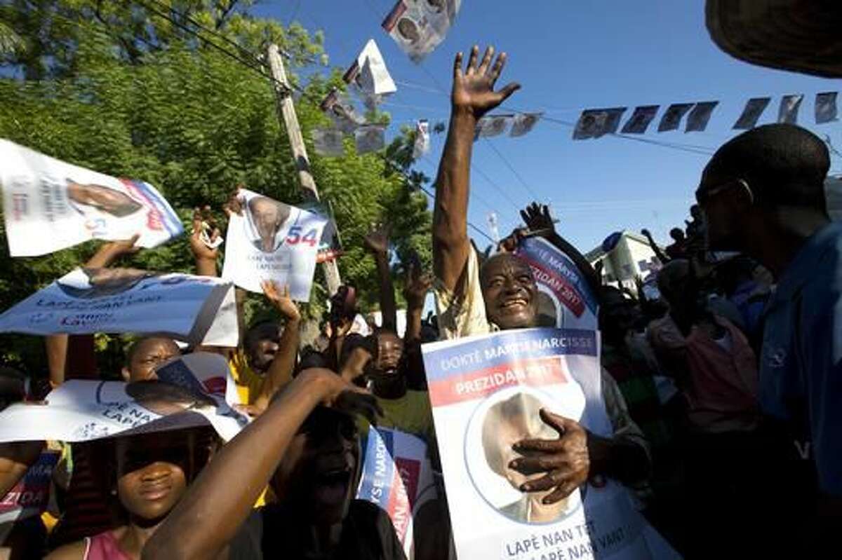 In this Wednesday, Nov. 16, 2016 photo, supporters of Fanmi Lavalas presidential candidate Maryse Narcisse, cheer her on at a campaign rally in Arcahaie, Haiti. While things have been relatively calm for a Haitian campaign season, there’s recently been an uptick in inflammatory rhetoric. Ex-President Jean-Bertrand Aristide, the most prominent surrogate campaigner for Fanmi Lavalas, recently made waves by calling for “dechoukaj” - Haiti’s word for its own brand of mayhem - if partisans believe they were cheated by an unfair vote. (AP Photo/Dieu Nalio Chery)