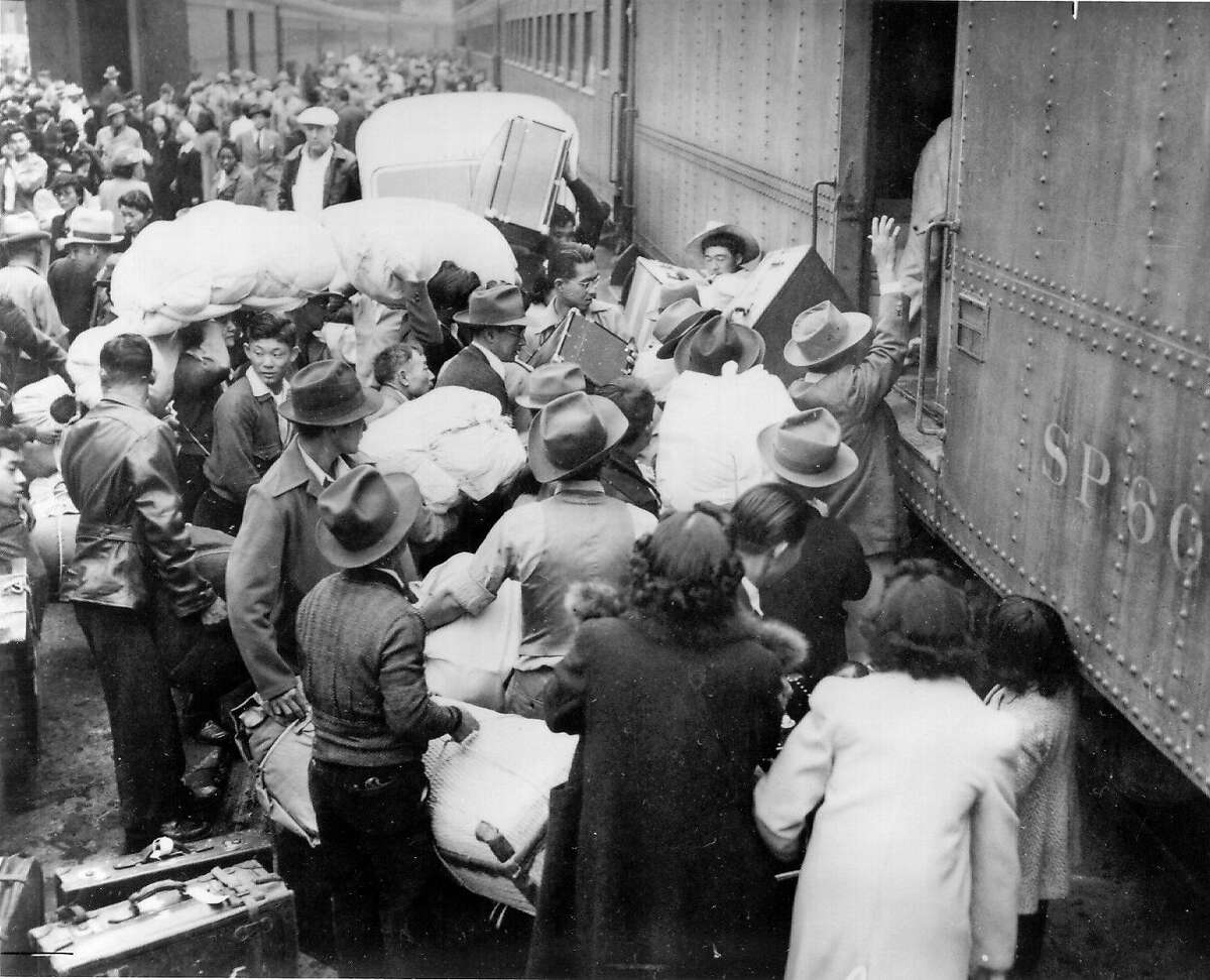 Hundreds of Japanese-Americans, allowed to keep only the belongings that they can carry, are forced onto trains bound for relocation centers Internment camps
