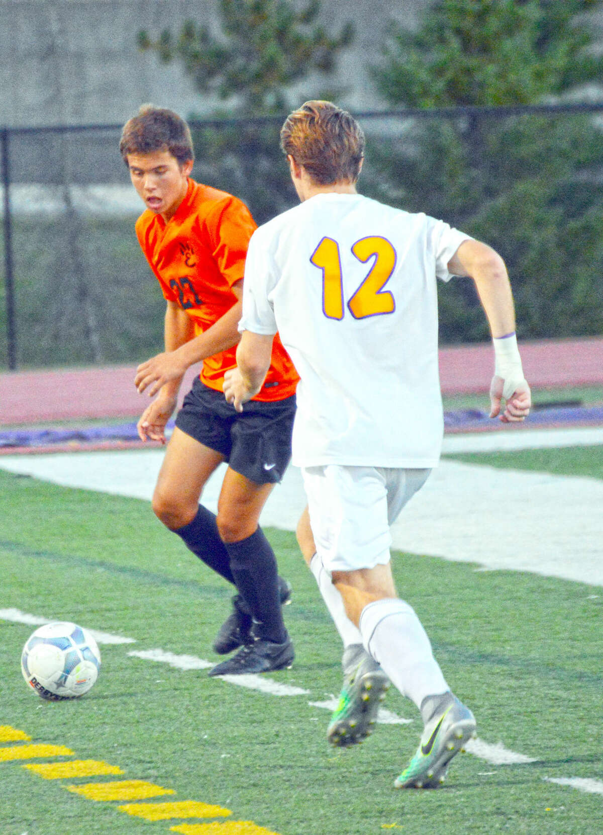 Edwardsville junior Zach Timmerman, left, prepares to clear the ball away from a CBC player.