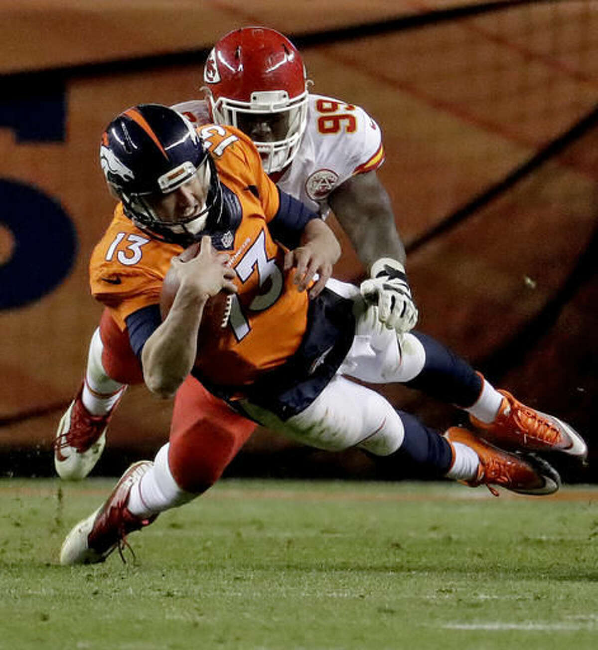Denver Broncos quarterback Trevor Siemian (13) dives as Kansas City Chiefs defensive tackle Rakeem Nunez-Roches (99) pursues during the second half of an NFL football game, Sunday, Nov. 27, 2016, in Denver. (AP Photo/Jack Dempsey)