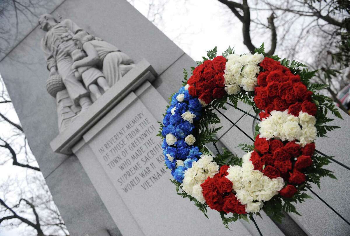 A red, white and blue wreath sits in front of the war memorial at the Greenwich Commons in downtown Greenwich, Conn. Monday, Dec. 8, 2014. The wreath was placed in front of the statue by WWII veteran Vin Masi on Sunday, the 73rd anniversary of the bombing of Pearl Harbor.