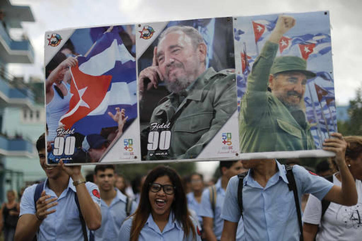 Young Cubans hold pictures of Fidel Castro as they arrive to attend a rally at the Revolution Plaza in Havana, Cuba, Tuesday, Nov. 29, 2016. Schools and government offices were closed Tuesday for a second day of homage to Fidel Castro, with the day ending in a rally on the wide plaza where the Cuban leader delivered fiery speeches to mammoth crowds in the years after he seized power.(AP Photo/Natacha Pisarenko)