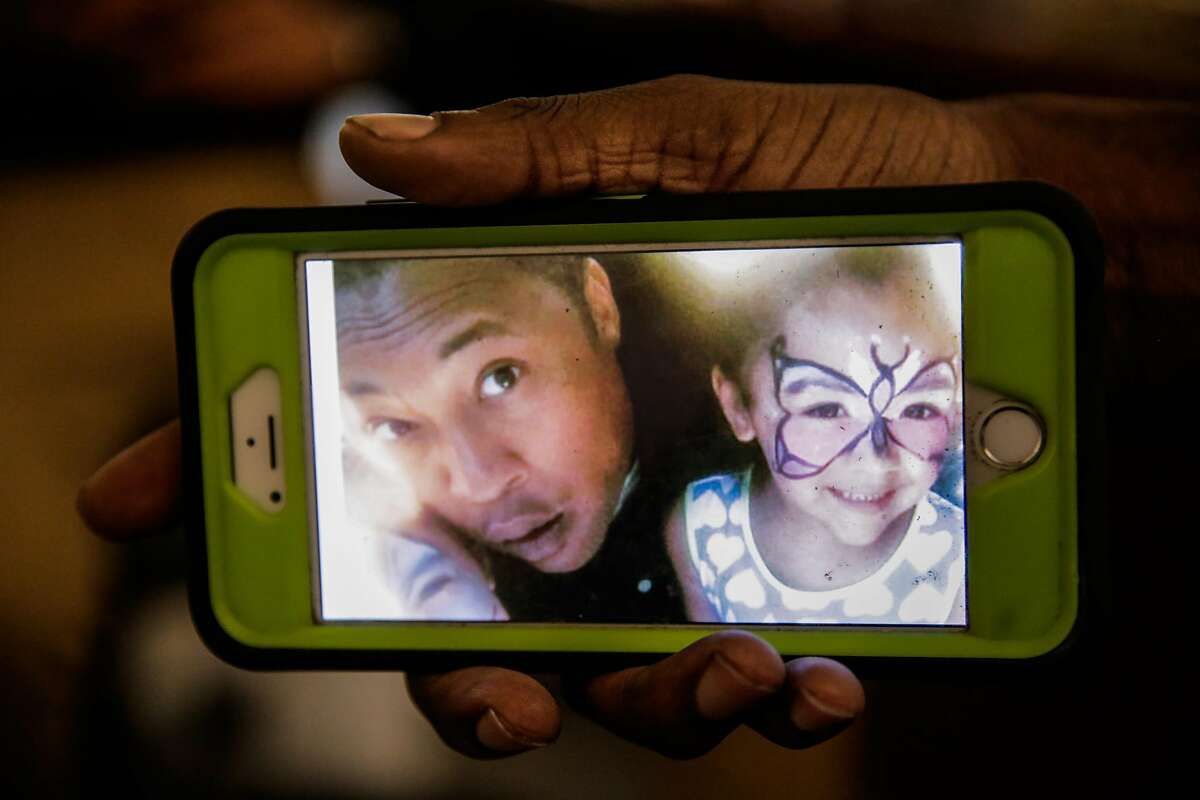 Kenzie Smith, 33, friend of Ghostship fire victim Alex Ghassan, holds a photo of his friend Alex pictured with Alex's daughter, during an interview at Captured Images Gallery and Framing in Oakland, California, on Tuesday, Dec. 6, 2016.