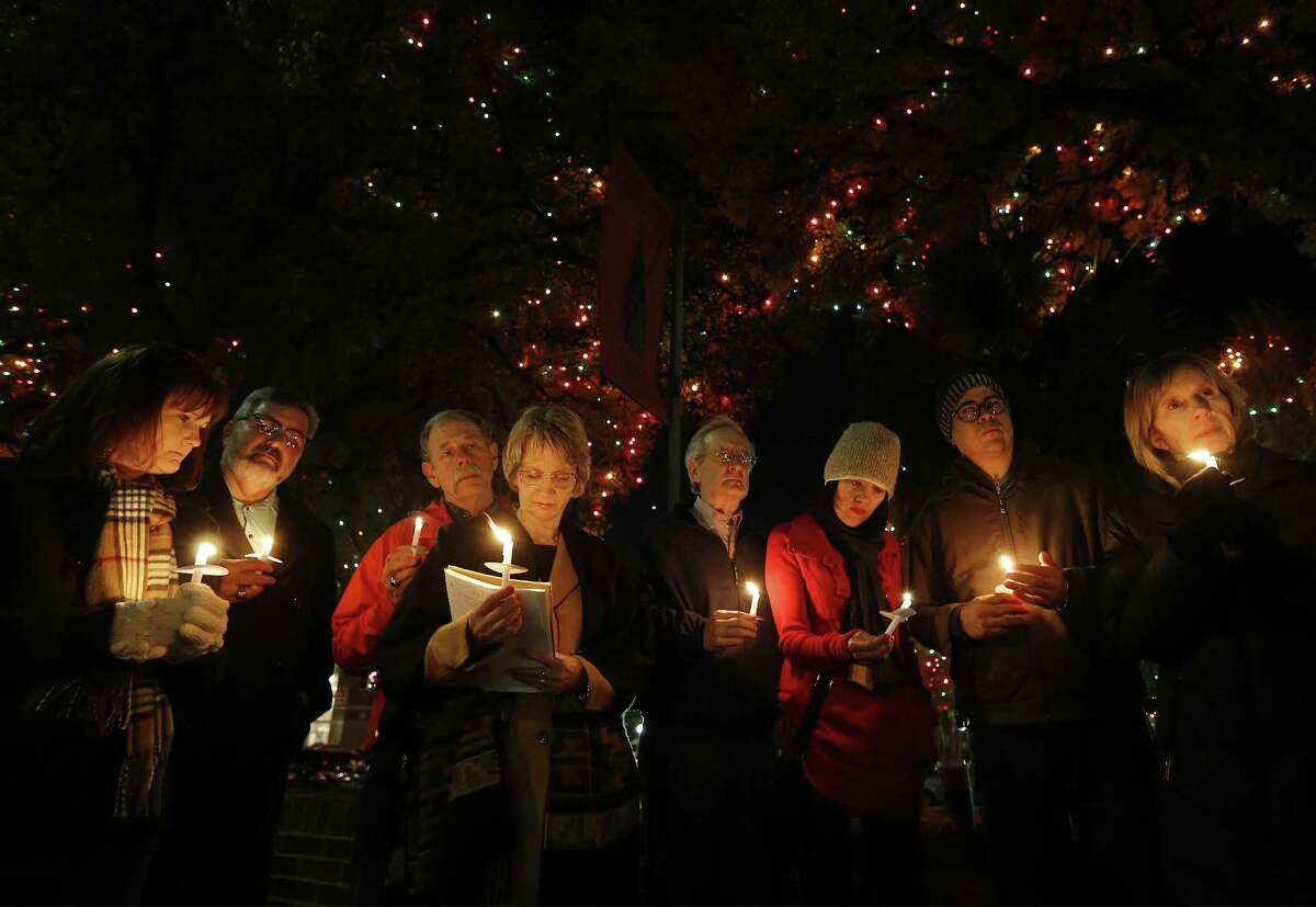Valerie Redus (fourth from left) and her husband, Mickey (third from left), join others in a candlelight vigil to mark the three-year anniversary of the death of their son, Cameron, in front of the University of the Incarnate Word on Tuesday, Dec. 6, 2016. Cameron was a student at UIW who was shot five times by a campus police officer in 2013. The vigil was held the night before the Redus family attorney goes before State Supreme Court with arguments in the wrongful death suit filed by the Redus family. About 40 people gathered for the vigil - many who were Cameron's classmates. (Kin Man Hui/San Antonio Express-News)