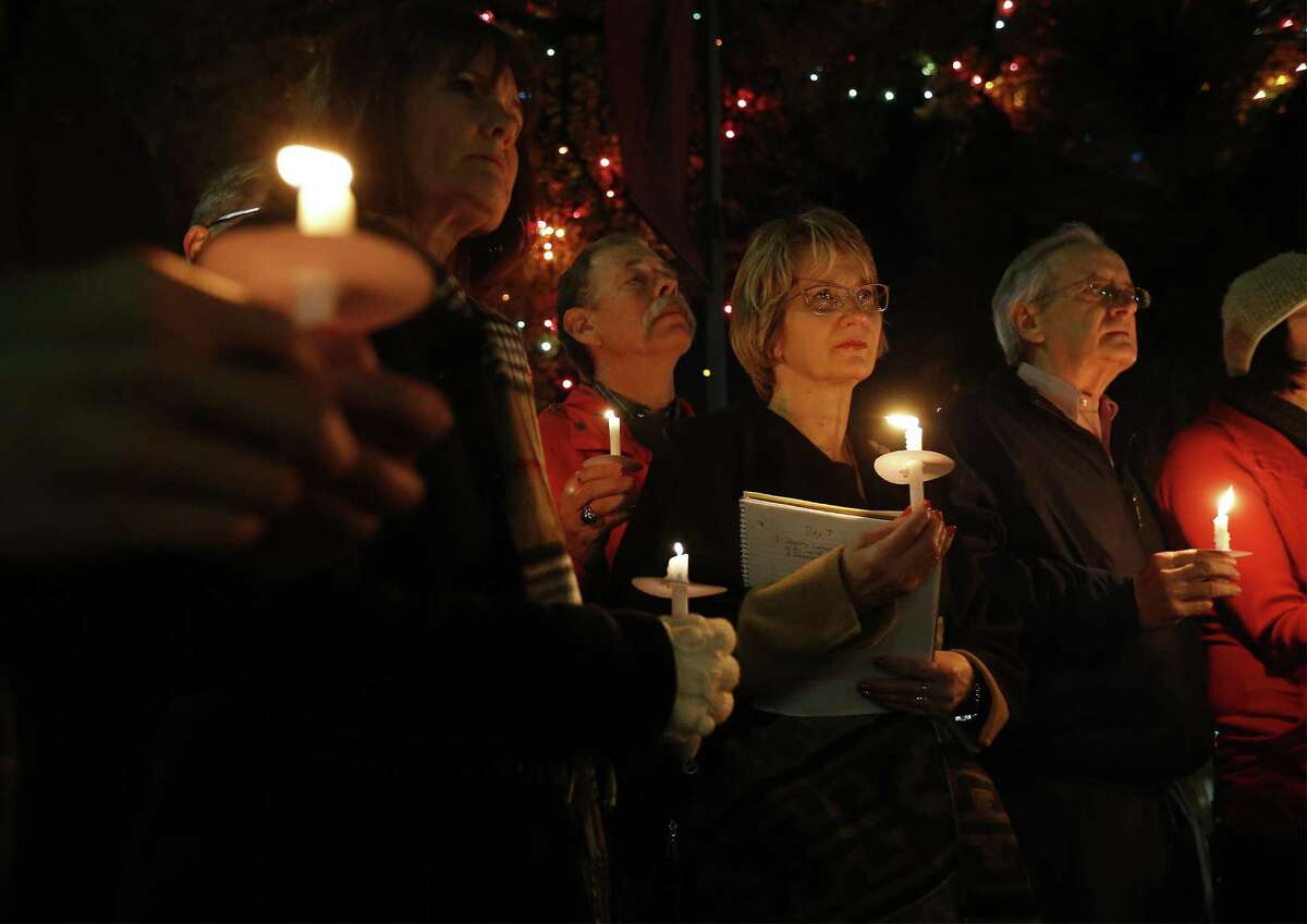 Valerie Redus (third from right) and her husband, Mickey (fourth from right), join others in a candlelight vigil to mark the three-year anniversary of the death of their son, Cameron, in front of the University of the Incarnate Word on Tuesday, Dec. 6, 2016. Cameron was a student at UIW who was shot five times by a campus police officer in 2013. The vigil was held the night before the Redus family attorney goes before State Supreme Court with arguments in the wrongful death suit filed by the Redus family. About 40 people gathered for the vigil - many who were Cameron's classmates. (Kin Man Hui/San Antonio Express-News)