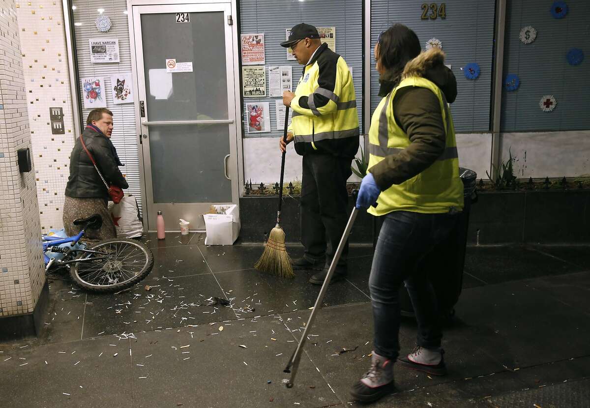 Director of Public Works Mohammed Nuru (center) tells a man sleeping in a doorway to move on so his department's TL Cares clean team can pick up trash in the Tenderloin in San Francisco, Calif. on Wednesday, Dec. 7, 2016.