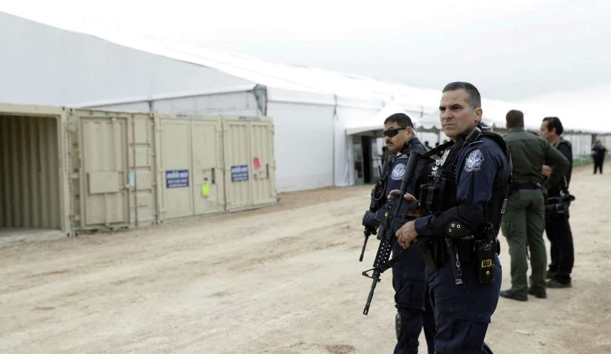 U.S. Customs and Border Protection agents stand outside a U.S. Customs and Border Protection temporary holding facility under construction near the Donna-Rio Bravo International Bridge, Wednesday, Dec. 7, 2016, in Donna, Texas. The tent facility, primarily to be used as a temporary holding site for children and families who have entered the county illegally, is due to open Friday and process up to 500 people a day. (AP Photo/Eric Gay)