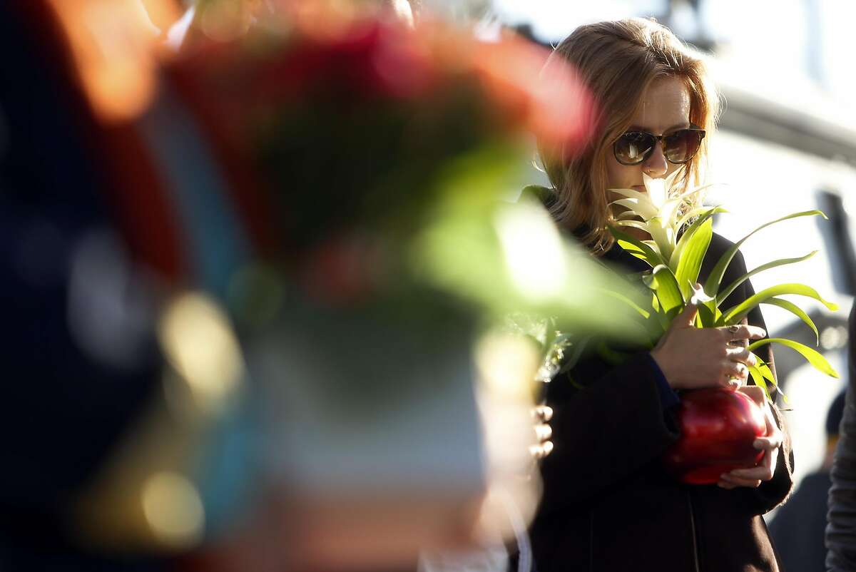 Genevieve Krause of Oakland pauses at memorial before placing a flower in the aftermath of the deadly Ghost Ship warehouse fire in Oakland, Calif., on Tuesday, December 6, 2016.