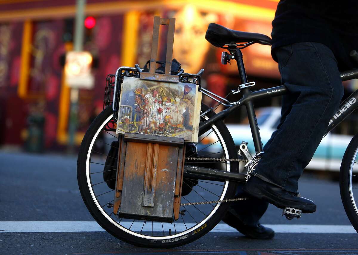 After painting a memorial on E. 12th Street, artist John Paul Marcelo of Oakland rides his bike home n the aftermath of the deadly Ghost Ship warehouse fire in Oakland, Calif., on Tuesday, December 6, 2016.