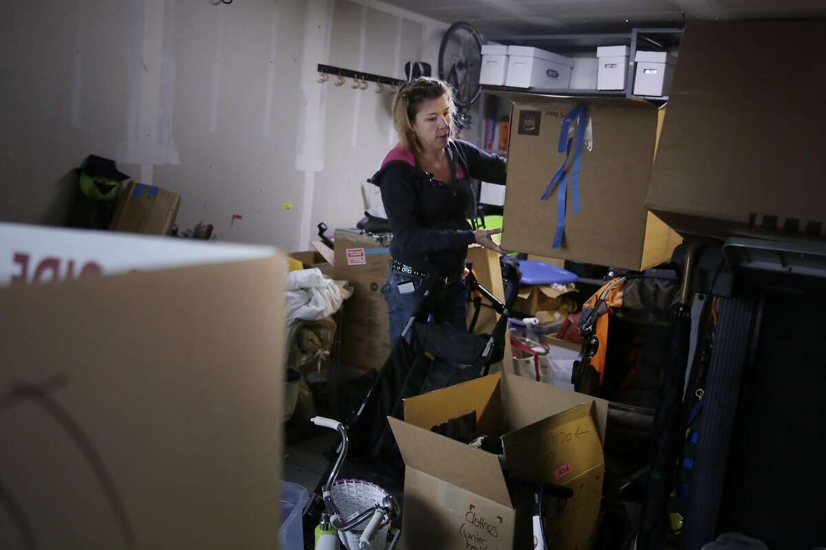 Heather Hawkins of San Francisco moves boxes and goes through belongings in her garage at her home as she prepares for her family's move to Truckee on Wednesday, December 7, 2016 in San Francisco, California.