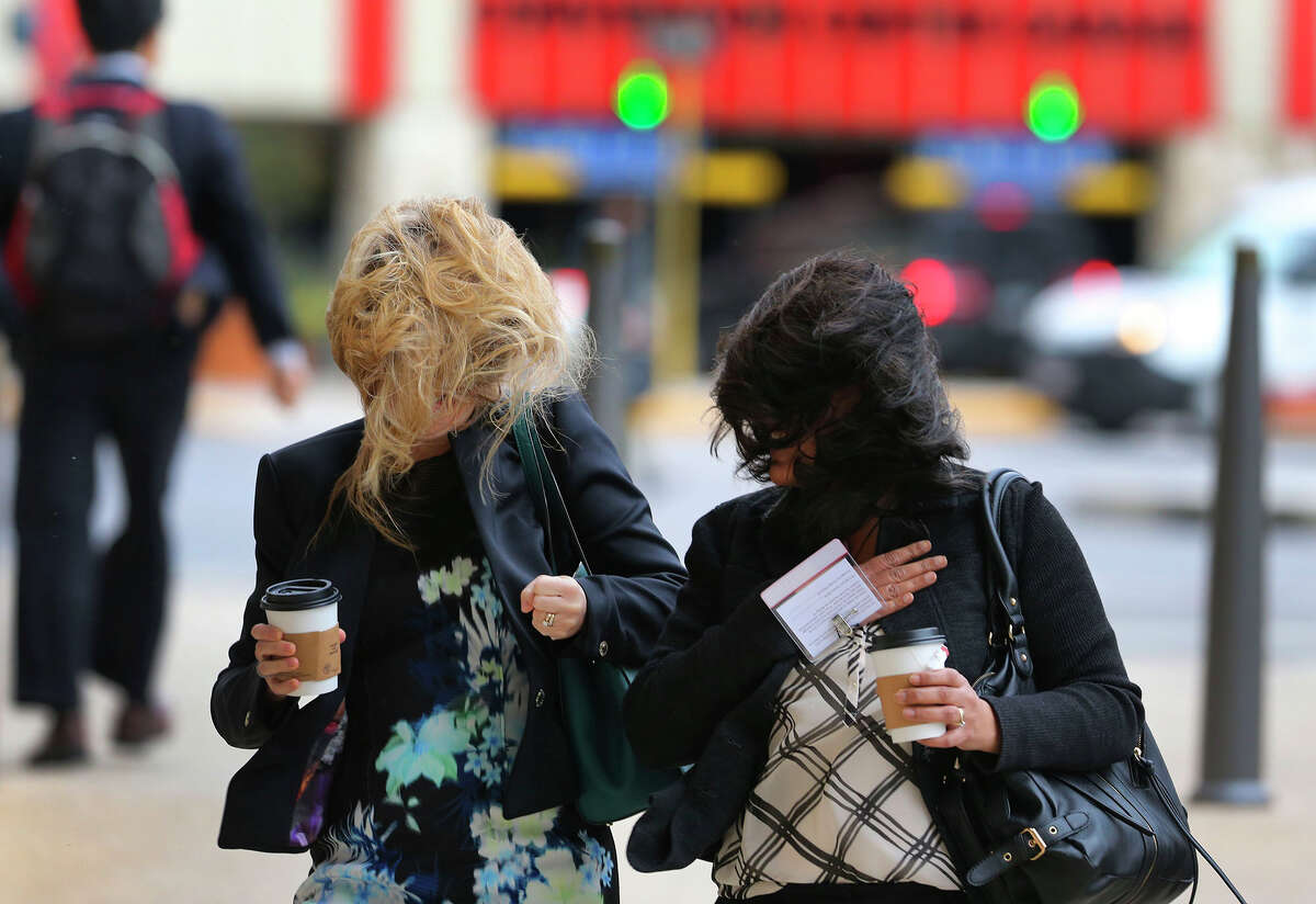 Pedestrians brave high winds in downtown San Antonio.