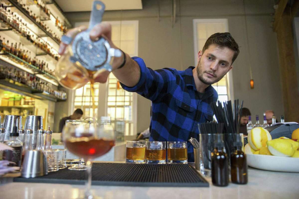 Steve James, a bartender, prepares drinks for customers at Hard Water.