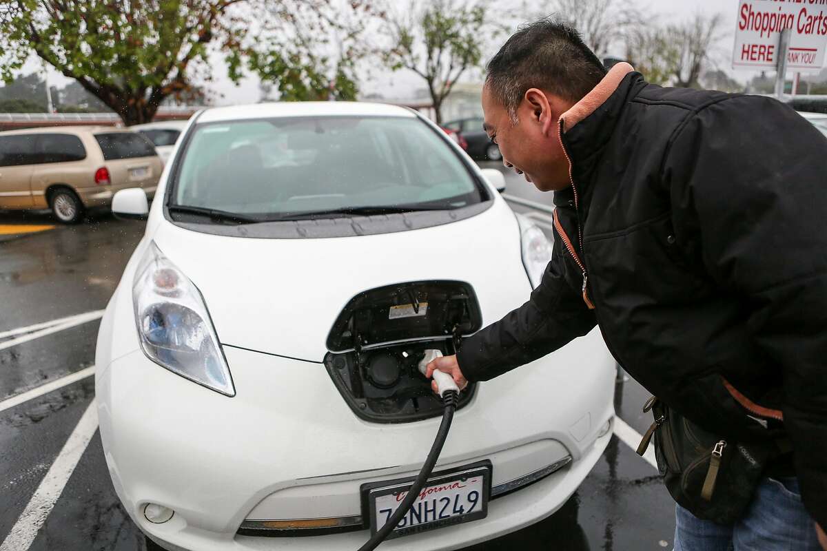 Joe Quan plugs in his electric car in one of the two public charging stations in the Stonestown Galleria parking lot while shopping on Thursday, December 8, 2016 in San Francisco, Calif.
