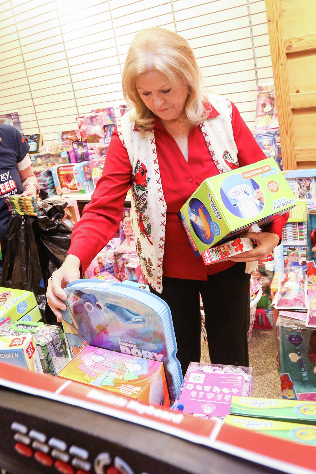 Volunteer Robin Massey-Crozier organizes donations for the Salvation Army on Friday, Dec. 9, 2016, at the Outlets at Conroe.