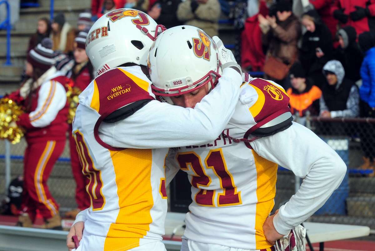 St. Joseph’s Josh Menard, left, embraces teammate Mike Dilorio on the sidelines after being defeated by Hillhouse Saturday.