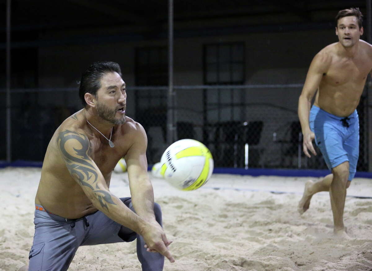 Teammates Johnny Tipton, left, and David Pearce play volleyball with their friends at Wakefield Crowbar Thursday, Dec. 1, 2016, in Houston. Wakefield Crowbar is a bar with three regulation-sized volleyball courts located in Garden Oaks. ( Yi-Chin Lee / Houston Chronicle )