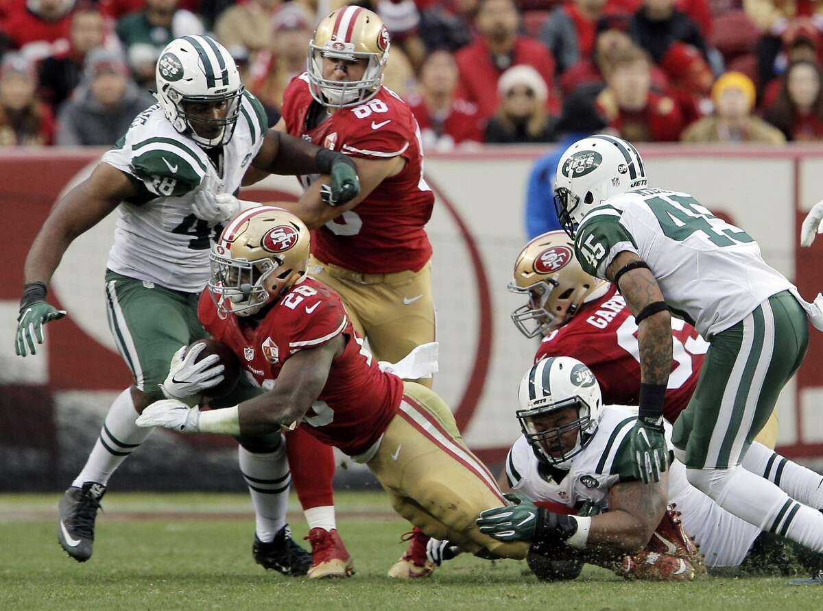 Carlos Hyde (28) is wrapped up by Deon Simon (93) in the second half as the San Francisco 49ers played the New York Jets at Levi's Stadium in Santa Clara, Calif., on Sunday, December 11, 2016. The Jets won in 23-17 overtime.