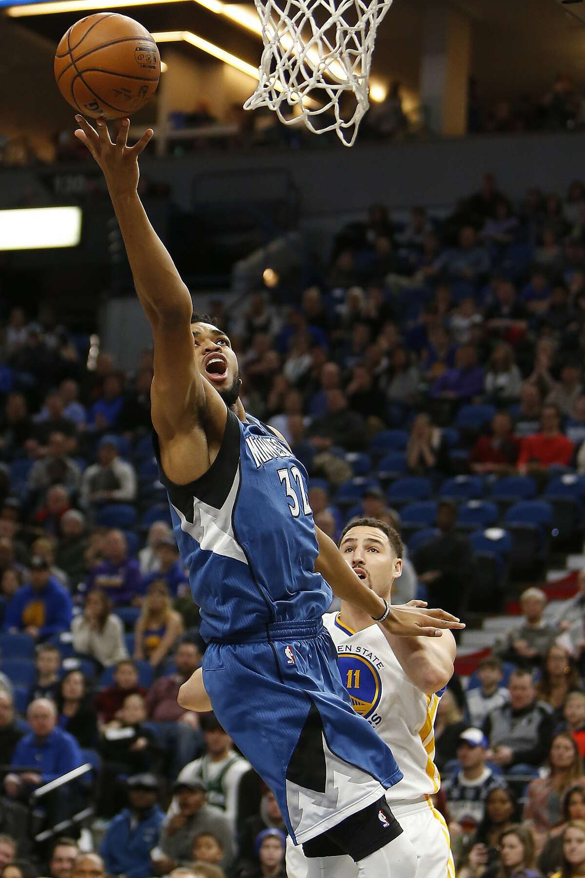 Minnesota Timberwolves center Karl-Anthony Towns (32) goes up to the basket past Golden State Warriors guard Klay Thompson (11) in the first half of an NBA basketball game, Sunday, Dec. 11, 2016, in Minneapolis. (AP Photo/Stacy Bengs)