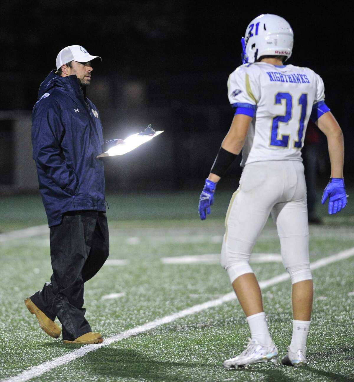 Newtown head coach Steve George talks with Matt Dubois (21) before the SWC football game between Newtown and New Milford high schools, on Friday night, September 30, 2016, at New Milford High School, New Milford, Conn.