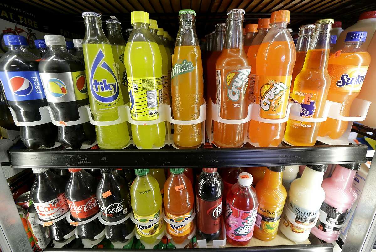 FILE - In this Wednesday, Sept. 21, 2016, file photo, soft drink and soda bottles are displayed in a refrigerator at El Ahorro market in San Francisco. After years of stamping out soda tax proposals with well-financed campaigns, Big Soda is suddenly finding itself up against bigger adversaries. In early November 2016, voters and lawmakers in five jurisdictions, including San Francisco and Chicago’s Cook County, approved special taxes on sugary drinks, with advocates chalking up the streak of victories to a shift in public attitudes. (AP Photo/Jeff Chiu, File)