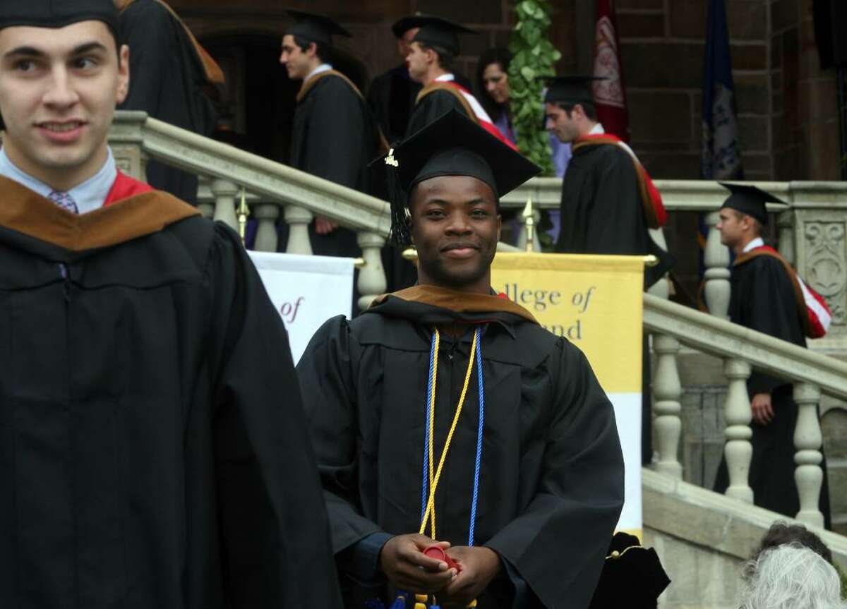 Emmanuel Ephie, center, of Nigeria, receives his diploma at Fairfield University's commencement ceremony on Sunday, May 23, 2010.