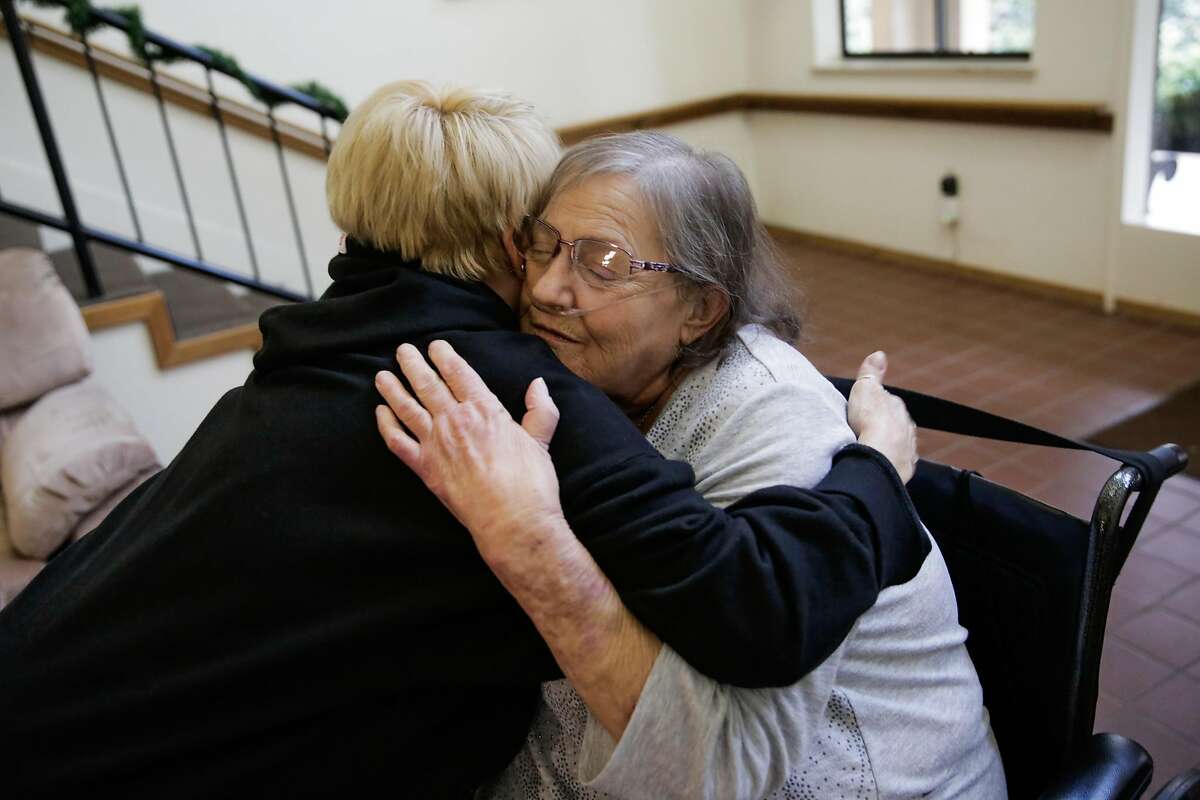 Sandra Quiroz (right), a senior who was recently evicted from a mobile home park when it was sold to a developer, gets a hug from her neighbor Irma Ward (left) at her senior apartment complex, in Benicia, Calif., on Sunday, Dec. 11, 2016. Quiroz, who is on oxygen and dialysis, was in danger of becoming homeless until the Benicia Community Action Council stepped in and found her a new place to live in an affordable senior housing residence.