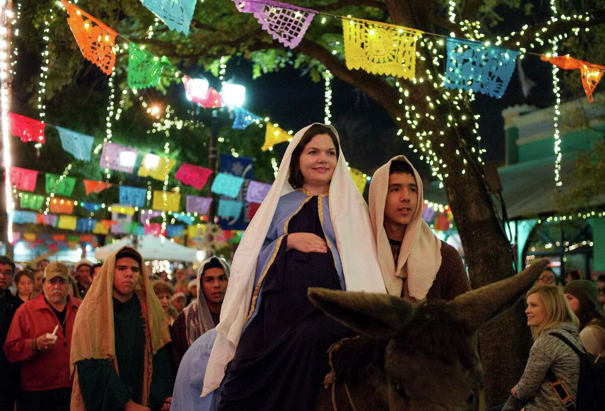FILE - Aimee Mandujano, left, as Mary, and Peter Vargas, as Joseph, ride atop a wheeled burro during La Gran Posada procession from Milam Park to San Fernando Cathedral, Sunday, Dec. 20, 2015, in San Antonio. The procession is a re-enactment of the Christmas story of Joseph and Mary's search for shelter in Bethlehem.